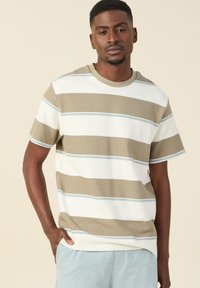 Gestreepte short-sleeve t-shirt in beige, wit en lichtblauw. Heeft een ronde halslijn en textuurstof. Ruimtevolle pasvorm met zijzakken.