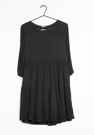 Schwarzes, knielanges Kleid mit Rundhalsausschnitt und Dreiviertelärmel. Verfügt über ein gestuftes Design aus weicher, strukturierter Stoff.