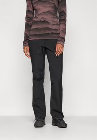 Zwarte broek met een rechte snit, voorzien van twee zijzakken en een gladde textuur, gecombineerd met een lange mouw met een patroon in tinten roze.
