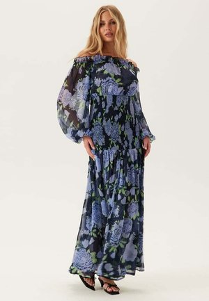 Maxi-jurk van doorschijnende stof, met blauwe bloemenpatronen op een donkere achtergrond, off-the-shoulder ontwerp en een vloeiende, gelaagde rok.