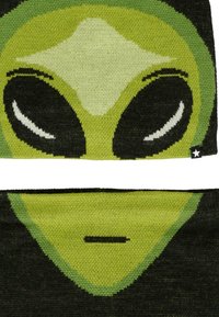 Set di maglieria verde e nera con un volto di alieno stilizzato, dotato di grandi occhi neri e una piccola bocca dritta.