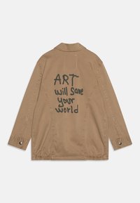Brun canvasjacka med öppen krage, lång ärm och elastisk nederkant. Baksidan visar stor svart text som säger "ART kommer att rädda din värld."