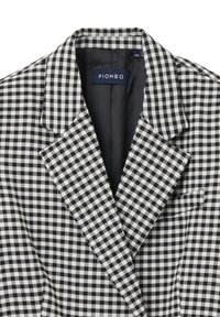 Blazer de cuadros vichy en blanco y negro con solapa, bolsillo en el pecho y forro negro suave. La etiqueta de la marca dice "PIOMBO."