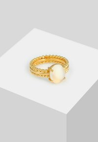 Guld ring med en glat, oval midte og to teksturerede bånd med små perler. Simpelt design, skinnende overflade.