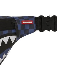 Riñonera con un diseño de cuadros azules y un gráfico de boca de tiburón. Presenta una etiqueta de logo roja y una correa negra ajustable con cierre de hebilla.