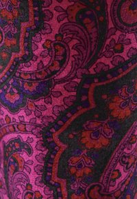 Livlig lila og pink paisley-stof med intrikate blomster-mønstre, der har accenter i rød og sort, let tekstureret overflade.