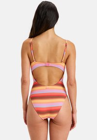 Gestreepte tankini met horizontale patronen in roze, oranje en bruin. Open rugontwerp met verstelbare bandjes en haaksluiting.
