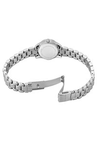 Montre en acier inoxydable argenté avec un fini poli, boîtier rond et bracelet à maillons. Détail de la boucle visible avec gravure de logo.