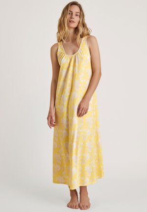 Geel bloemen nachthemd gemaakt van lichte stof. Heeft een ronde hals, geplooide details en een vloerlange ontwerp met een ontspannen pasvorm.