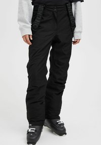 Black snow pants with adjustable straps featuring "BEND NOT" printed. Made from waterproof material, designed with a relaxed fit and reinforced knees.