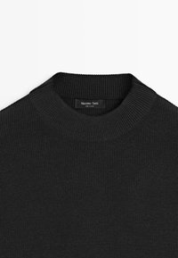 Pull en maille côtelée noire avec un col rond. Présente une étiquette portant la mention "Massimo Dutti". Le matériau semble doux et texturé.