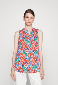 Camisola sem mangas floral em vermelho, azul, verde e branco, apresentando um colarinhohalter e fecho de botão à frente com um corte solto e tecido suave.