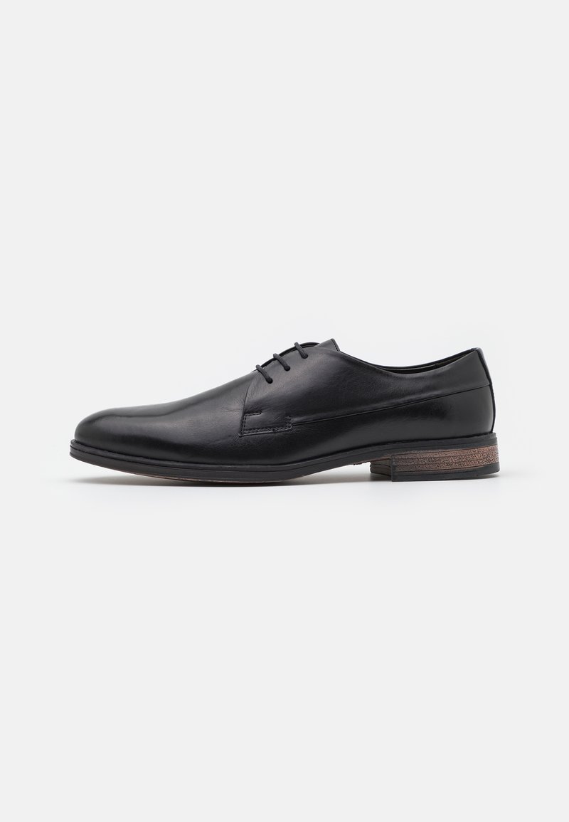 Schwarze Lederschuhe mit glatter Oberfläche, Schnürdesign, runder Zehenform und einem kontrastierenden, strukturierten braunen Absatzakzent.