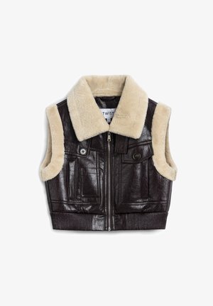 Brown leather cropped vest with cream faux shearling collar, zip closure, and two front pockets. Ribbed hem and textured fabric.