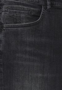 Schwarze Denim-Jeans mit einem leicht ausgebleichten Finish, ausgestattet mit einer Vordertasche und dezenten dekorativen Nähten. Der Stoff hat eine glatte Textur.