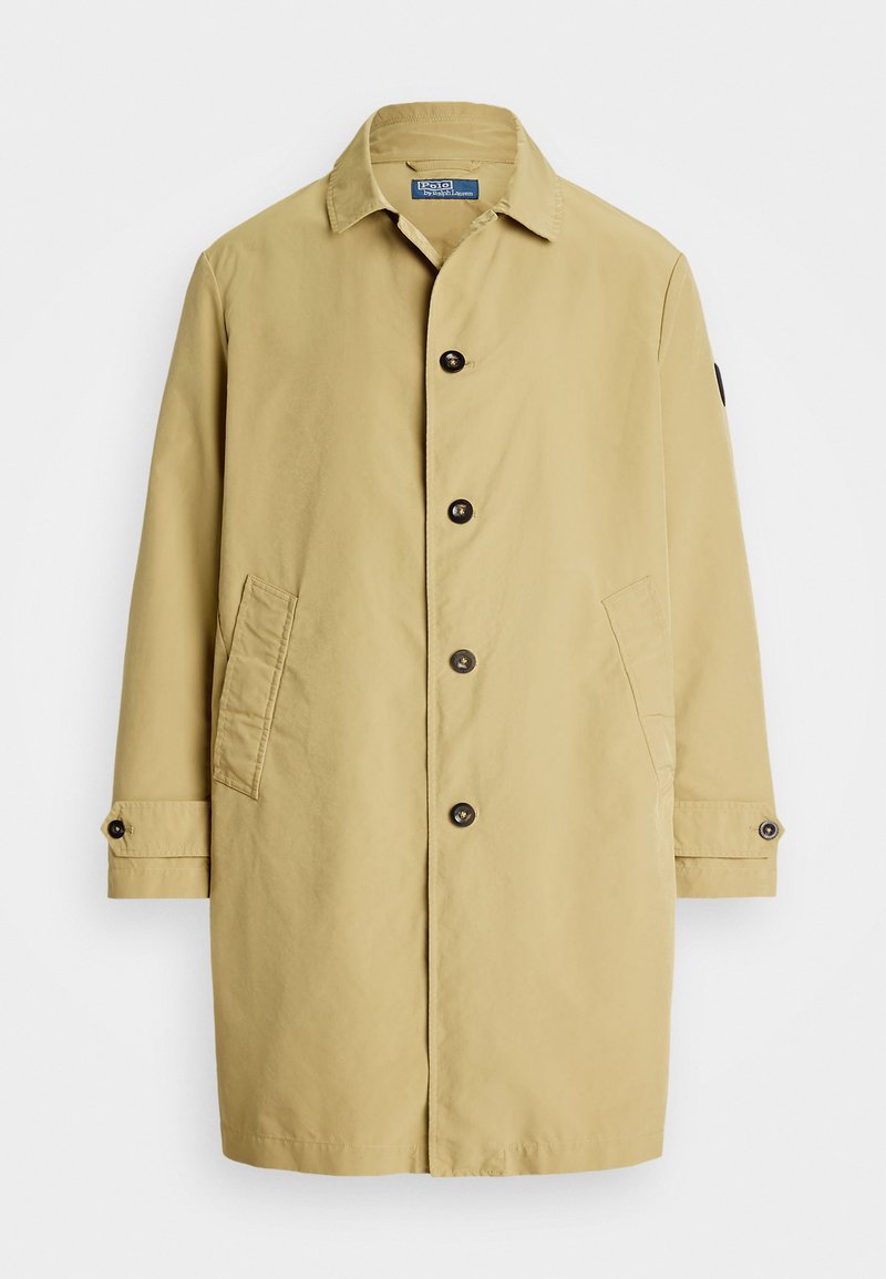 Bežinis, vidutinio ilgio paltas, pagamintas iš lengvos medžiagos. Turi apykaklę, priekiniai mygtukai, šoninės kišenės ir mygtukais užsegami rankogaliai.