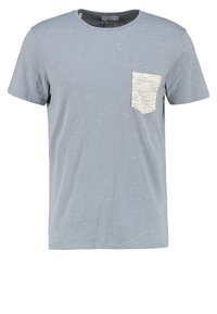 Ljusblå bomulls-T-shirt med en texturerad yta, korta ärmar och en kontrastfärgad vit ficka på vänster bröst.