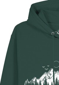 Donkergroene hoodie met een witte afbeelding van bergen, dennenbomen, vogels en een zon, zichtbaar nabij het midden onderaan.