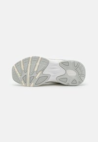 Sneakersåle med en flerfarget grå gummibunn, med spor for grep, beige aksenter og en teksturert overflate.
