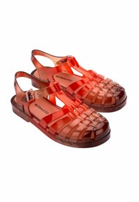 Chanclas de plástico rojo translúcido con un diseño tejido abierto, correa ajustable y punta redondeada. Presentan una plantilla de marca y suela texturizada.