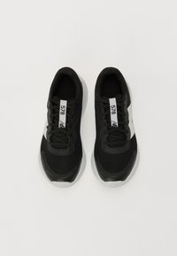 Czarne sportowe buty z siateczkową cholewką, białymi akcentami i wyściełaną podeszwą. Posiadają sznurowadła i metkę z numerem 578.