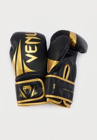 Μαύρα και χρυσά γάντια πυγμαχίας από συνθετικό δέρμα, με κομψό σχέδιο, τολμηρή επωνυμία, επενδεδυμένα γροθιά και ρυθμιζόμενους ιμάντες στον καρπό.