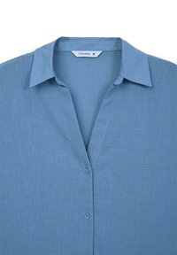 Camicia azzurro chiaro realizzata in tessuto testurizzato, con colletto a punta, chiusura con bottoni e design dal taglio rilassato. Etichetta della taglia visibile all'interno.