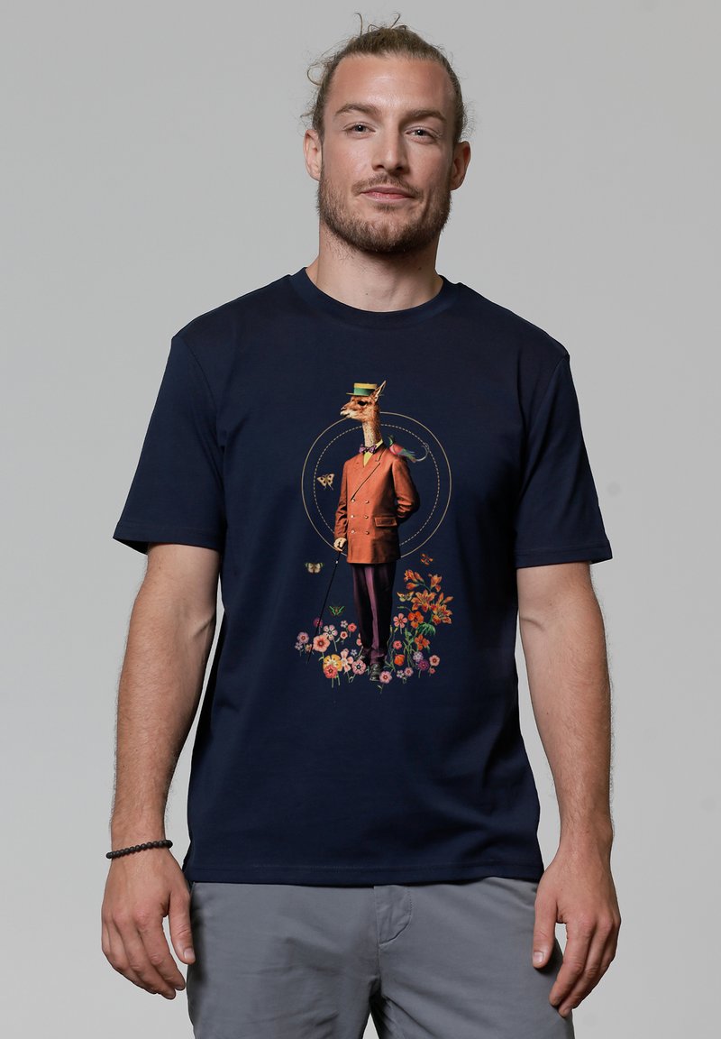 Navys-blaues T-Shirt mit einem verspielten Grafikdesign eines gekleideten Giraffen in Anzug mit Blumen, Schmetterlingen und einem Stock, gedruckt in lebhaften Farben.
