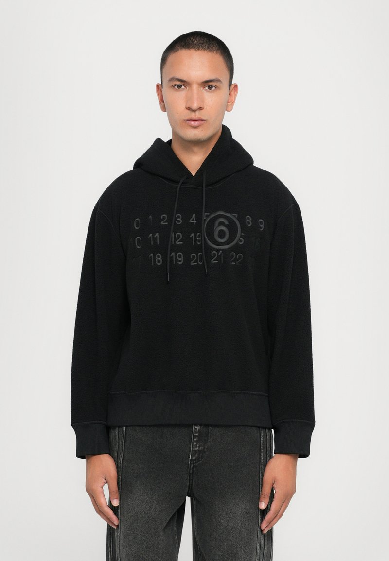 Svart fleece hoodie med en känguruficka, med präglade siffror och en cirkulär grafisk design på framsidan, samt ribbad nederkant och ärmslut.
