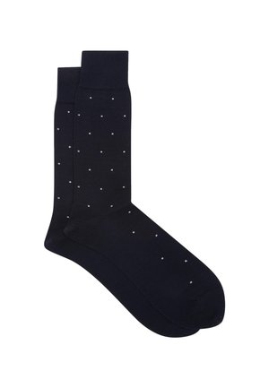 Een paar zwarte sneakersokken met een klein wit stippenpatroon en geribbelde boorden, plat gelegd op een witte achtergrond.