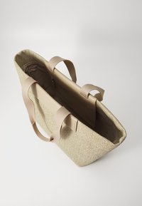 Beige geflochtene Tragetasche mit glatten, tanfarbenen Tragegriffen und einem geräumigen Innenraum. Enthält eine Reißverschlusstasche zur Organisation.