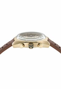 Zlatý hodinky s hnedým koženým remienkom, vybavené textúrovaným ciferníkom, priehľadným sklom a dvoma tlačidlami s logom na pozícii 3 hodín.