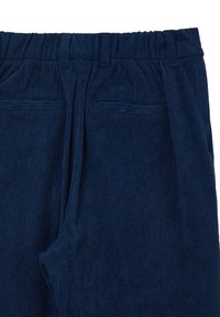 Pantalons en velours côtelé bleu marine dotés d'une texture côtelée, d'une taille élastique et de deux poches frontales. Le tissu semble doux et durable.