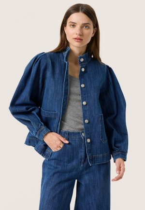 Jachetă din denim cu un corset ajustat și mâneci bufante, având un guler în picioare, nasturi tip capse și două buzunare laterale, într-o nuanță de albastru închis.