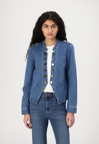 Denim jacket in medium blue, featuring a cropped design, military-style buttons, and a structured collar. Smooth texture with long sleeves.