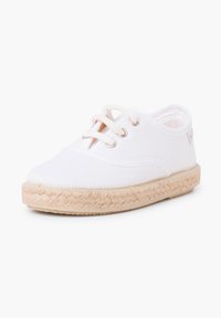 Chaussure en toile blanche avec bout rond, design à lacets et semelle en jute tissée. Équipée d'œillets métalliques et d'une marque minimaliste sur le côté.