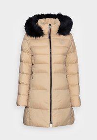 Béžová prošívaná péřová bunda s horizontálním designem, černou kapucí z umělé kožešiny, předním zipem a logem na levé horní straně.