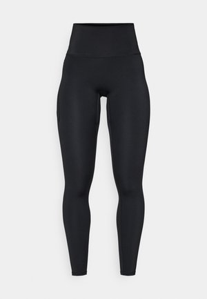 Leggings noirs taille haute en matériau extensible, avec une texture lisse, une coupe ajustée et des poches latérales.