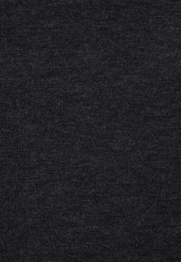 Tissu gris foncé texturé avec un motif tissé subtil, montrant des fibres fines et de légères variations de couleur dans le matériau.