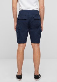 Shorts cargo de culoare albastru marin, cu buzunare laterale, talie elastică și margini răsucite, fabricate dintr-un material ușor.