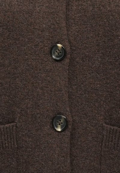 Pruun villast kardigan pehme tekstuuriga, millel on kaks musta nuppu ja kaks küljetaskut. Klassikaline disain, sobib kihiliseks kandmiseks.
