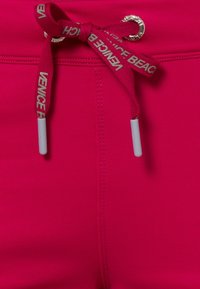 Roze zwemshorts met een gestructureerde stof, voorzien van een trekkoord met de opdruk "VENICE BEACH" en witte plastic uiteinden aan het trekkoord.