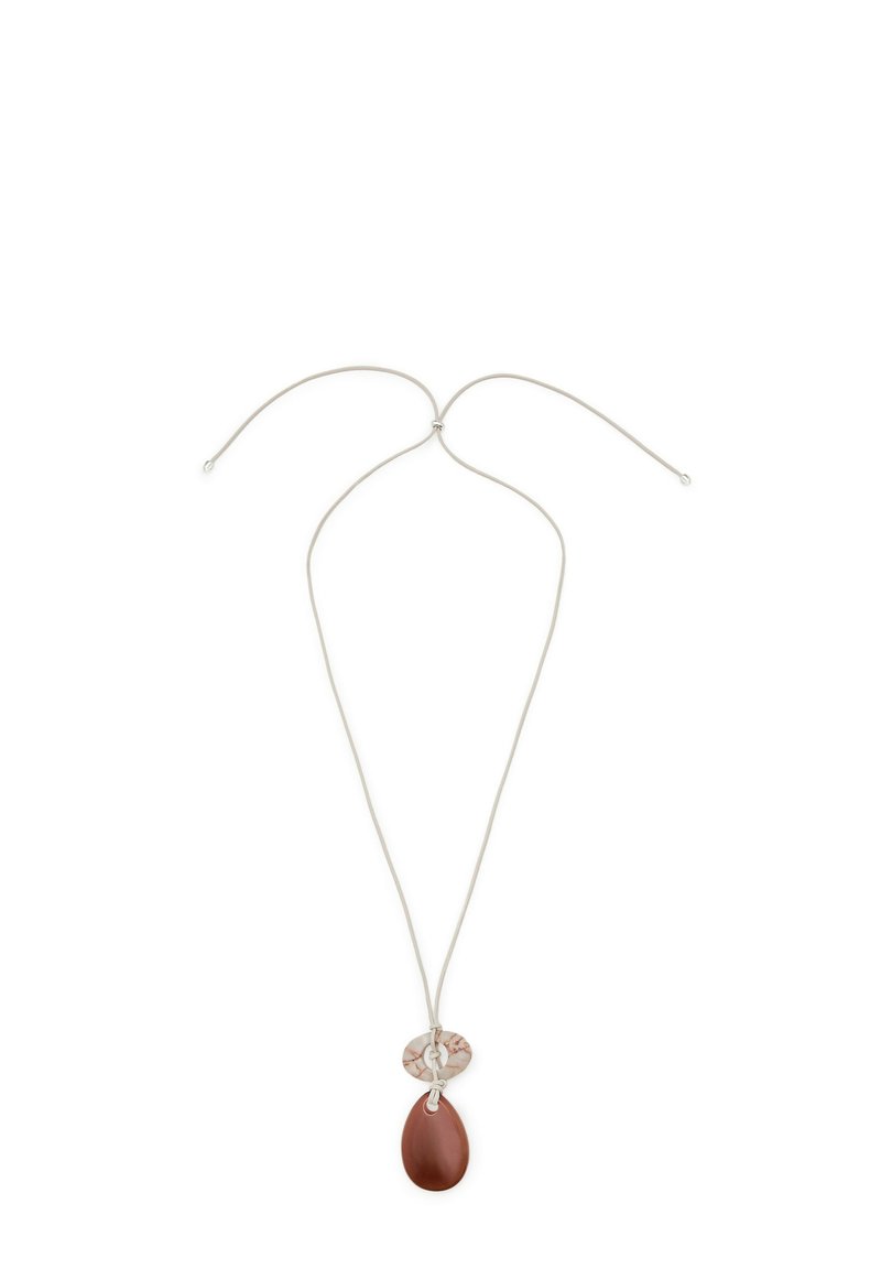 Brun tårnpendant på en tynd sølvsnor, med et rundt, mønstret accentstykke over pendanten. Glat tekstur, minimalistisk design.