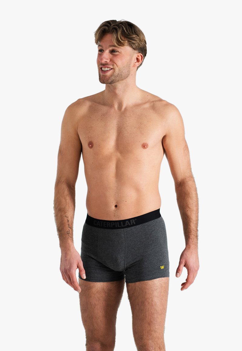 Boxers en coton gris avec une ceinture noire arborant le logo "CATERPILLAR". Notez le design ajusté et la texture douce adaptée au confort.