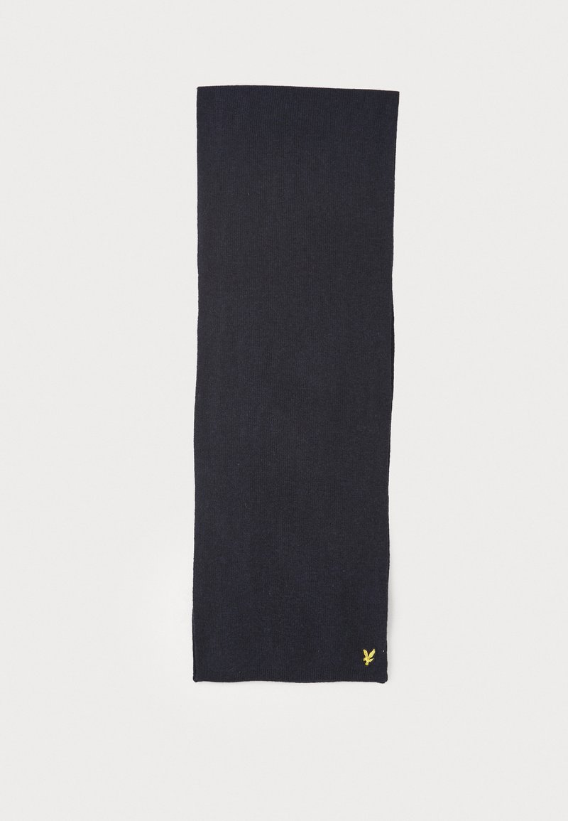 Écharpe en tricot bleu marine, de forme rectangulaire, texture douce, avec un petit logo jaune dans le coin inférieur. Design simple et monochromatique.