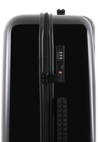 Black hard-shell suitcase with a dual zipper, built-in combination lock, and textured side panel. Features a sleek, glossy finish.
