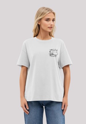 White cotton t-shirt with short sleeves, featuring a black graphic "Smiley Originals" printed on the left chest area.