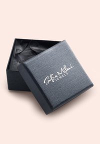 Schwarze strukturierte Schmuckbox mit einem Deckel, der das weiß bedruckte Logo "Sofia Milani Jewels" zeigt. Im Inneren befindet sich schwarzes Seidenpapier.