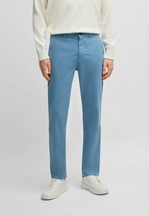 Light blue, straight-leg trousers made of smooth fabric, featuring a button and zip closure, and side pockets. Worn with a white sweater and sneakers.