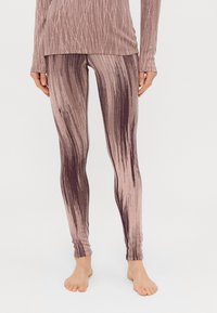 Leggings com um design em degradê apresentando tons de rosa e castanho, feitos de um material macio e elástico com linhas verticais texturizadas.